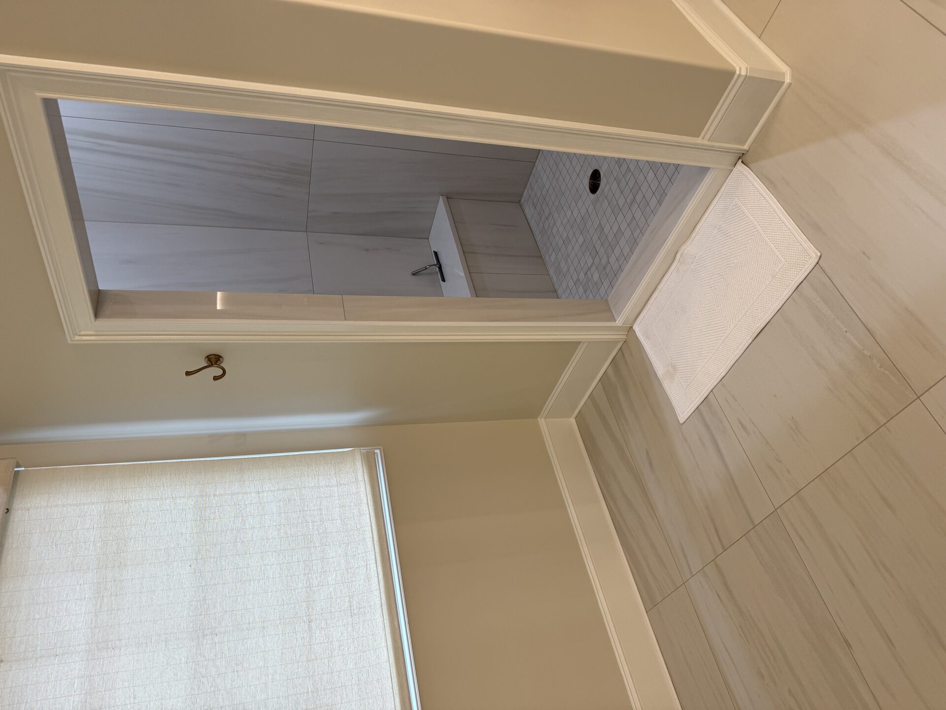 Finished walk-in shower with built-in bench and large-format stone-look floor tile in the Marchbanks primary bathroom in Greer, SC