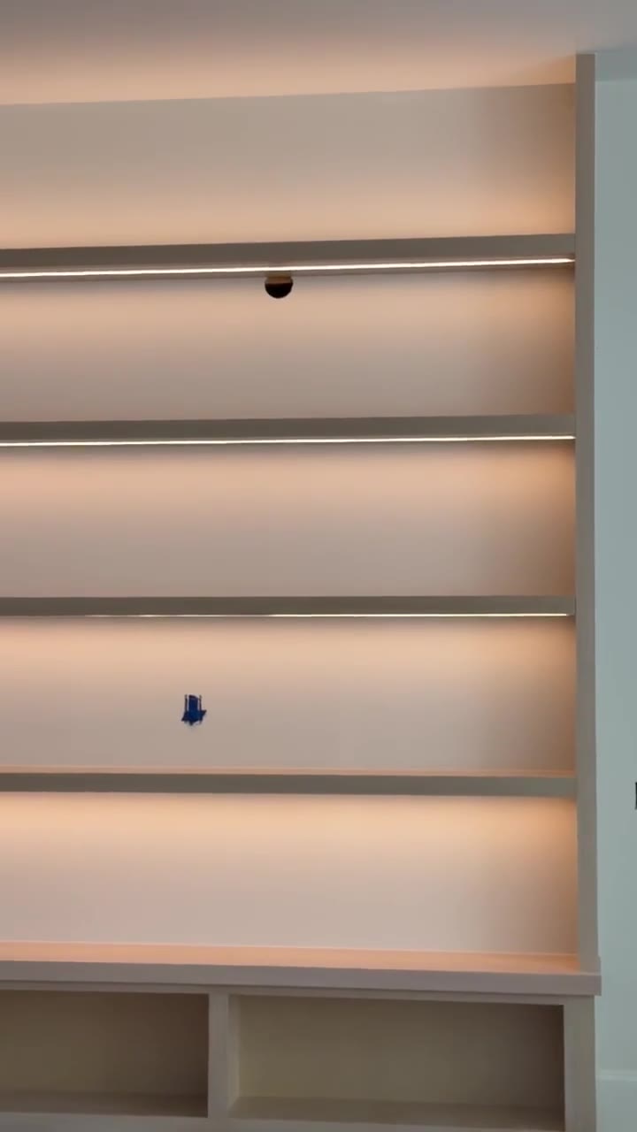 Floor-to-ceiling floating shelves with concealed LED strip lighting over a built-in bench in a high-end Chesnee, SC build